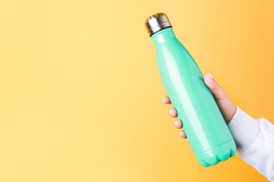 Female hand with blue water bottle.