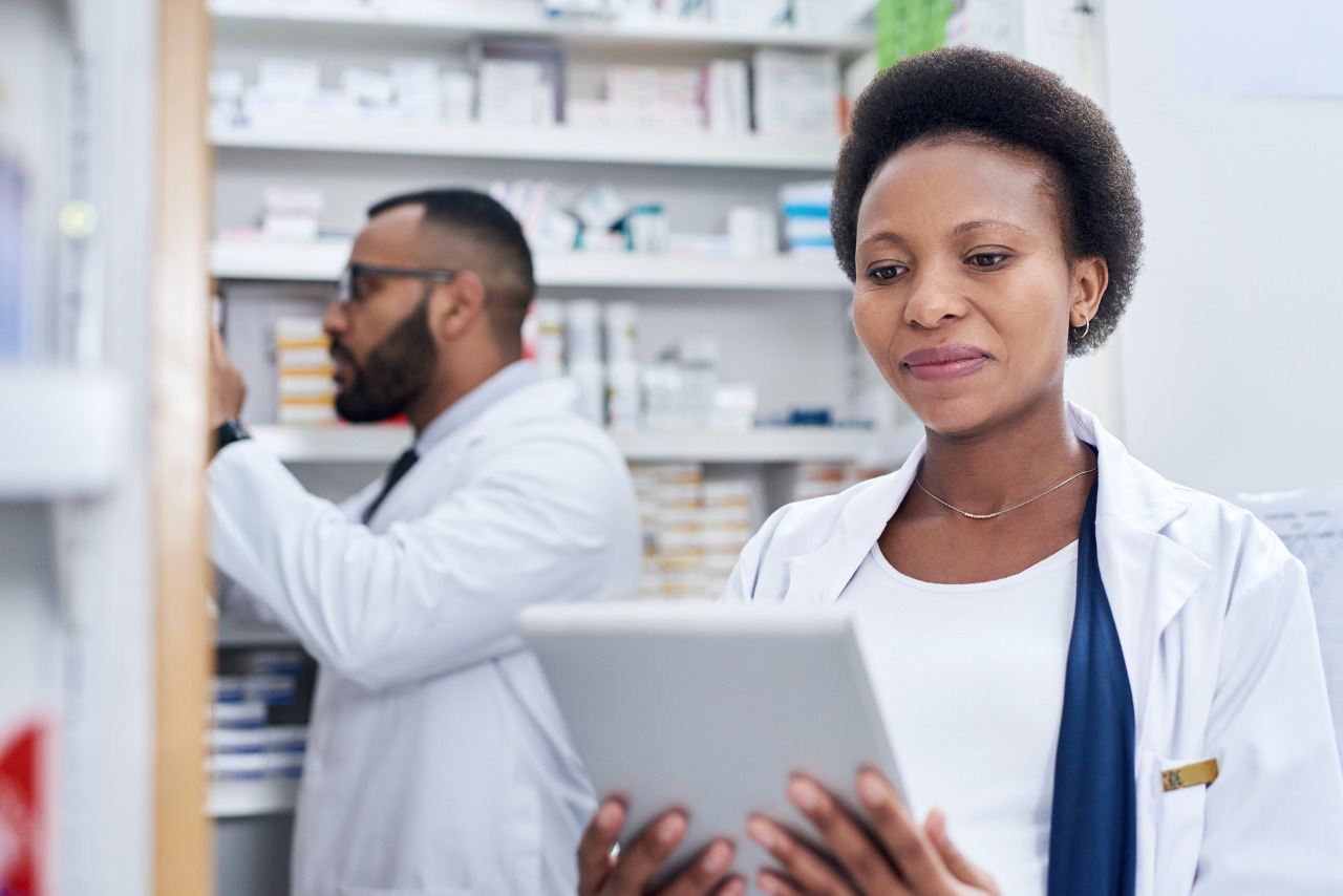 Male and female pharmacist working in pharmacy and checking on online prescription.