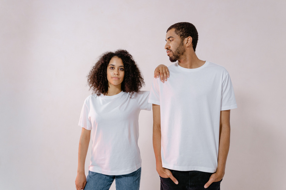 Man looking at woman, both in white t-shirt.