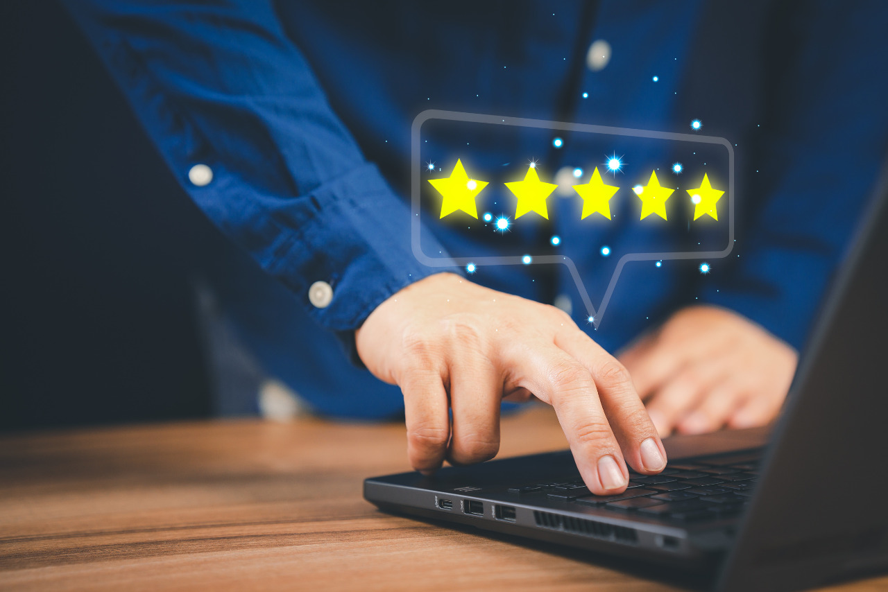 Man using laptop computer to rate service experience.
