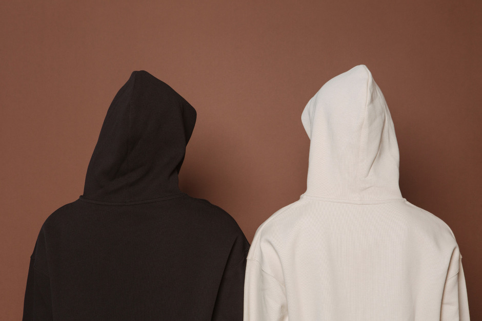 Models and black and white hoodies backview in studio.