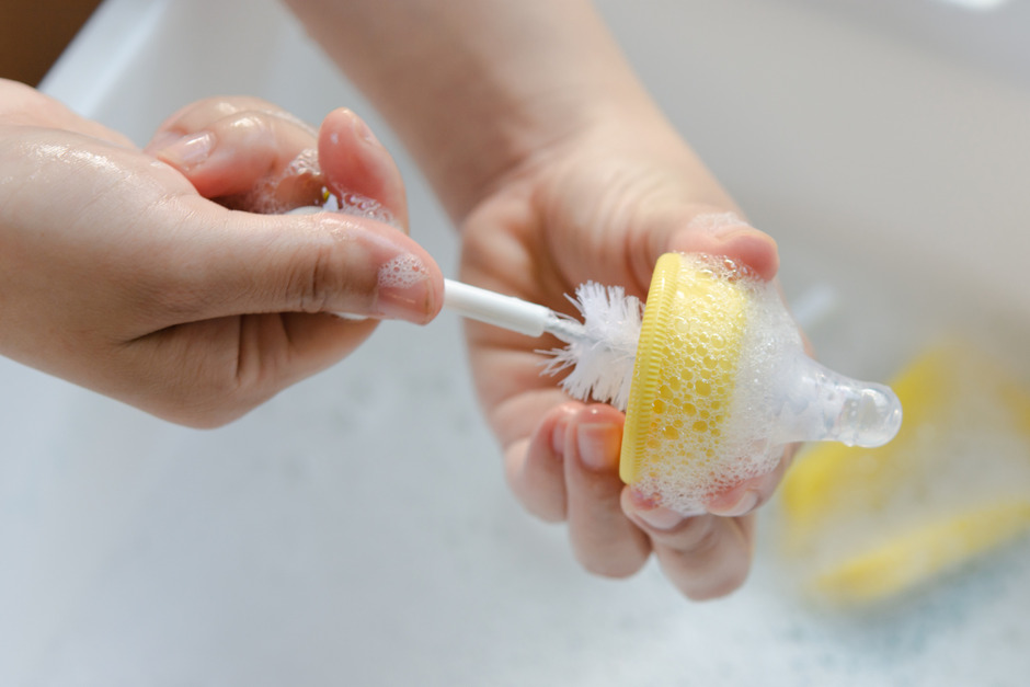 Mother's hand washing the baby nipples.