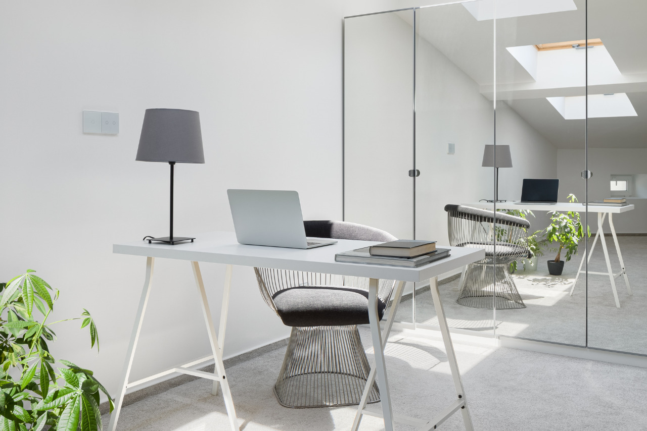 Office area with white simple desk in attic room.