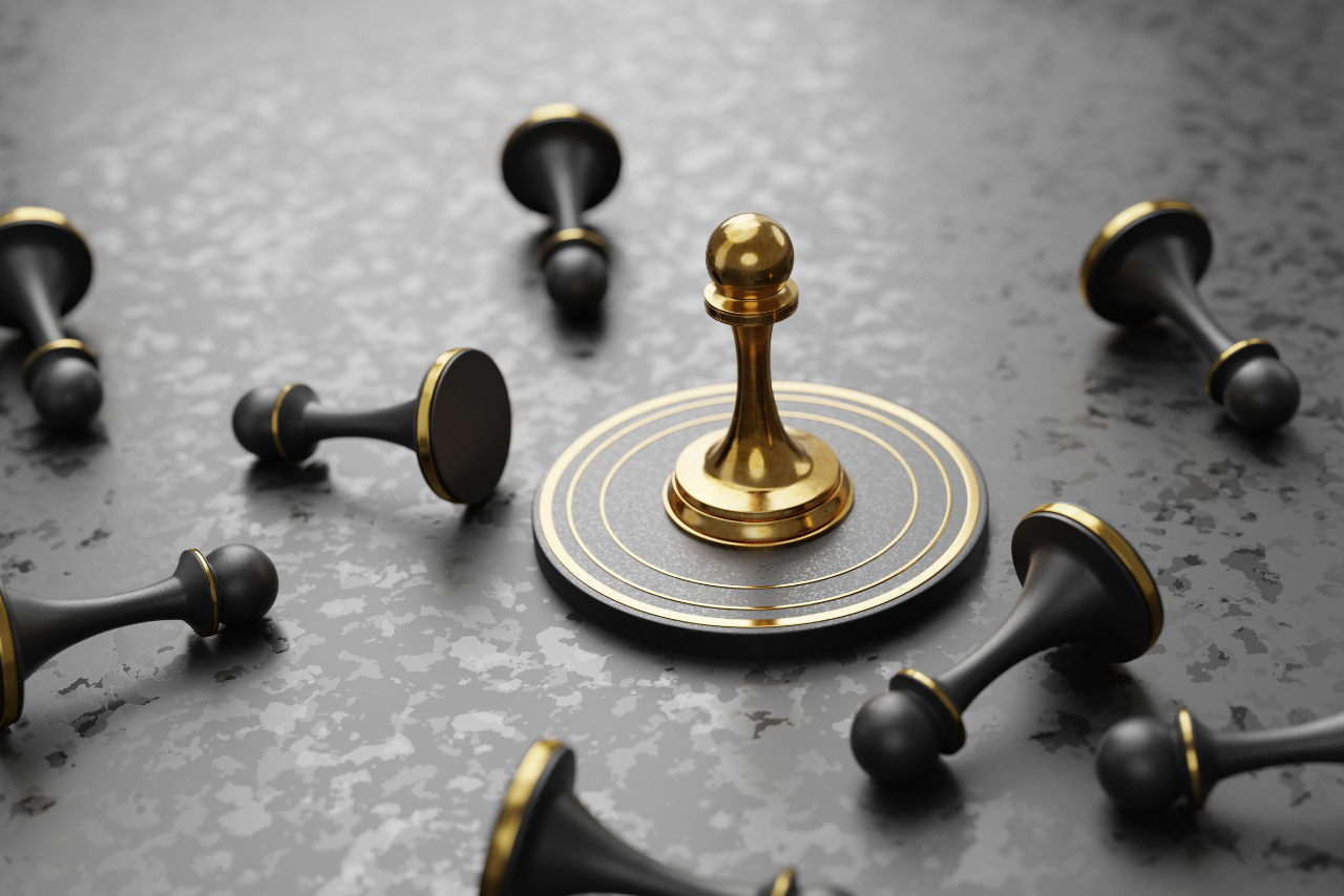 One golden pawn standing among black ones.