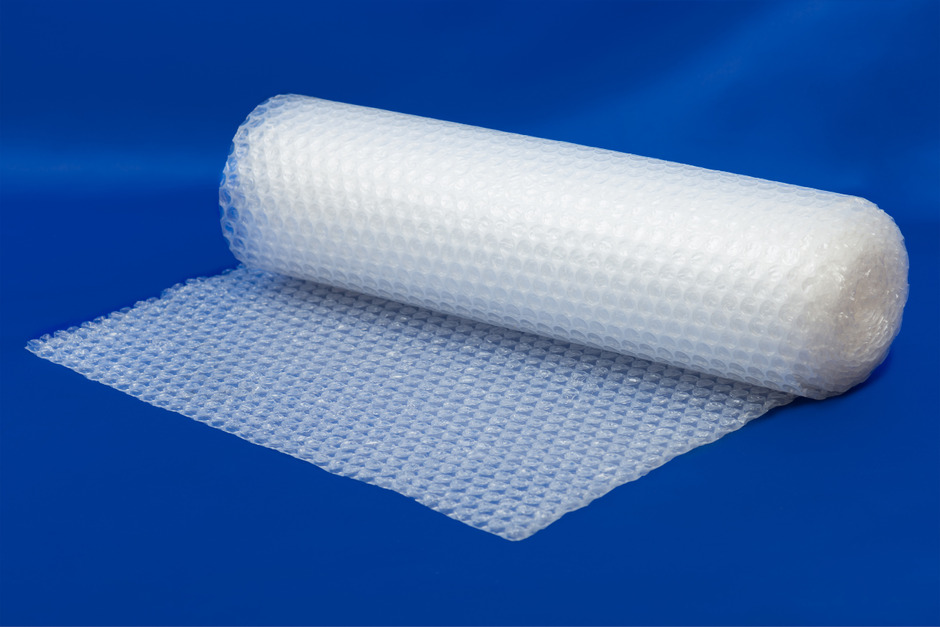 Packaging bubble wrap roll on blue.