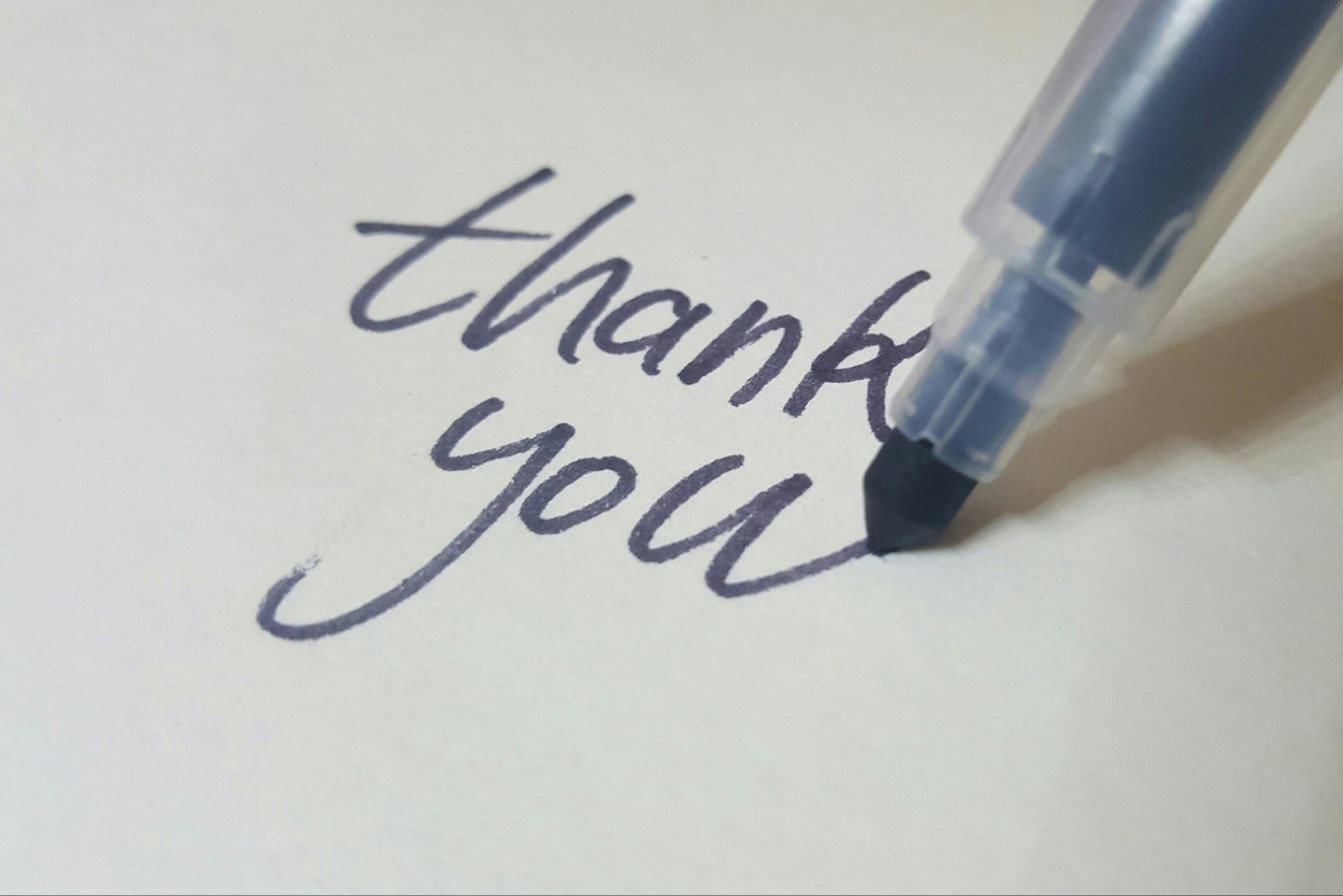 Pen Writing Thank You on White Background.