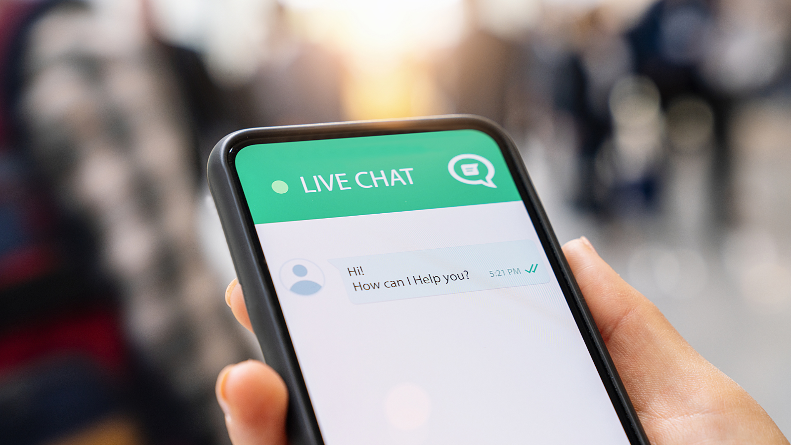 Person's hand using smartphone chatting with live support.