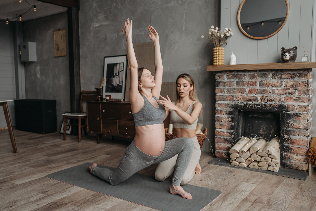 Pregnant Woman Doing Yoga with instructor.