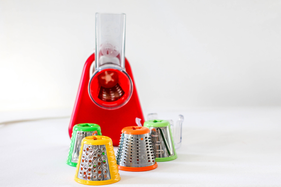 Red vegetable chopper with four different blades.