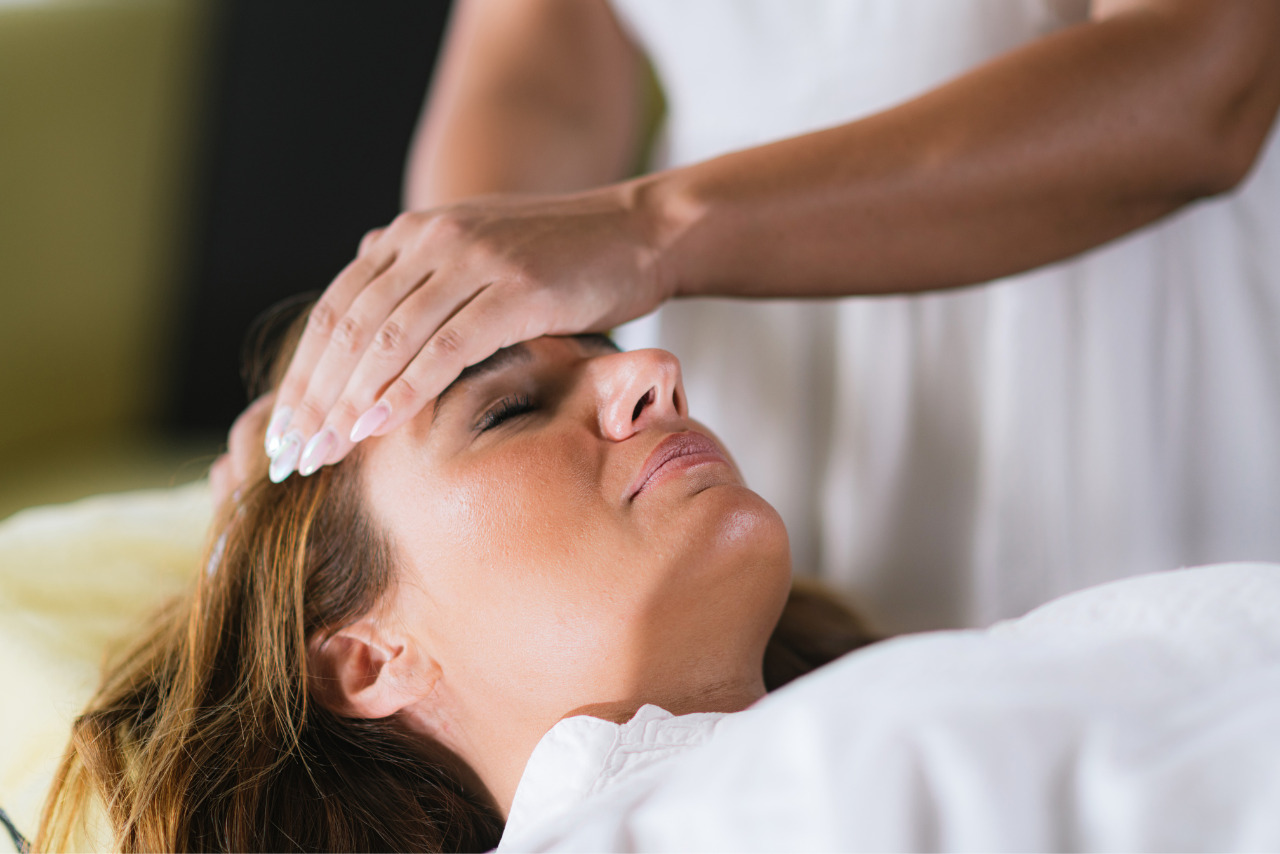 Reiki practitioner holding female patient's head with two hands.