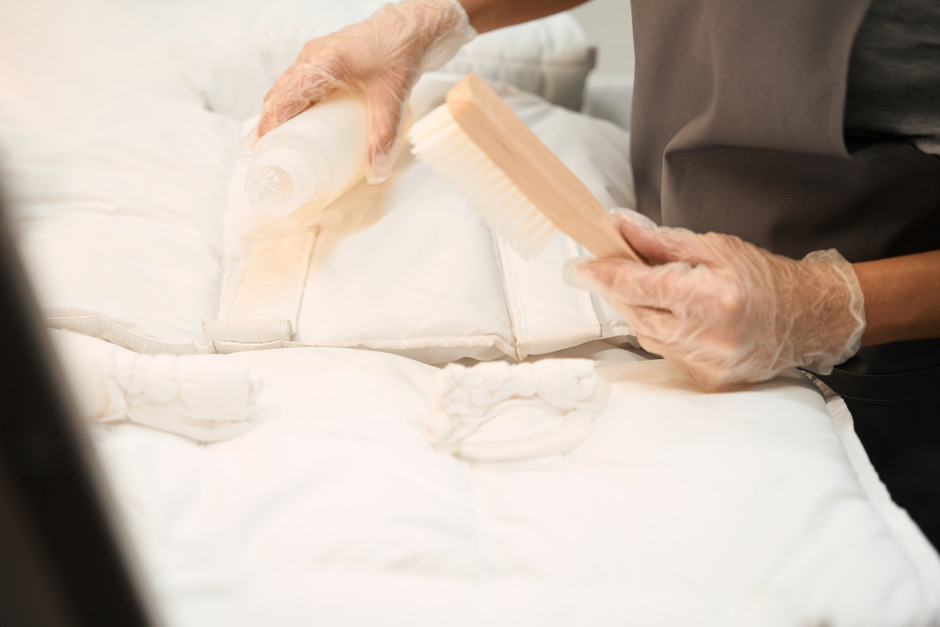 Skilled worker of dry-cleaning applying stain removal agent at delicate fabric.