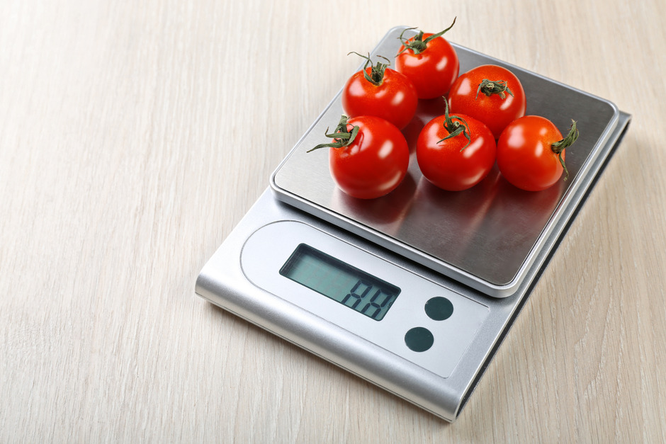 Tomatoes on digital kitchen scale.