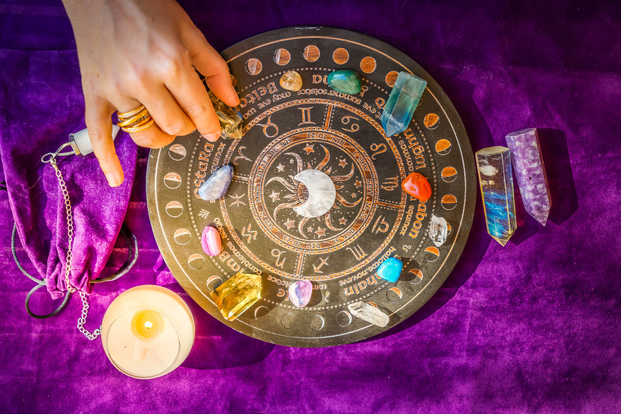 Top View of Astrologer Hands with Zodiac Horoscope with crystals.