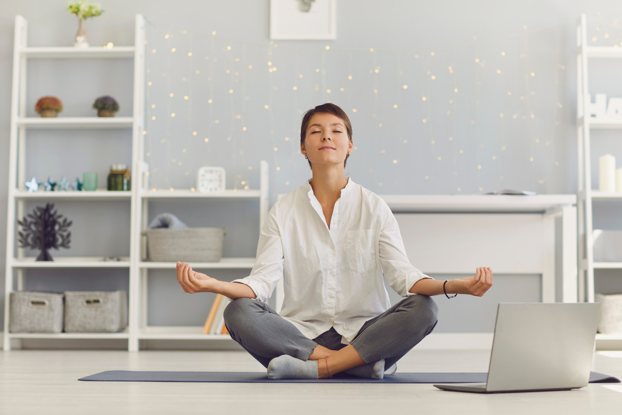 Woman blogger meditates infront of laptop.