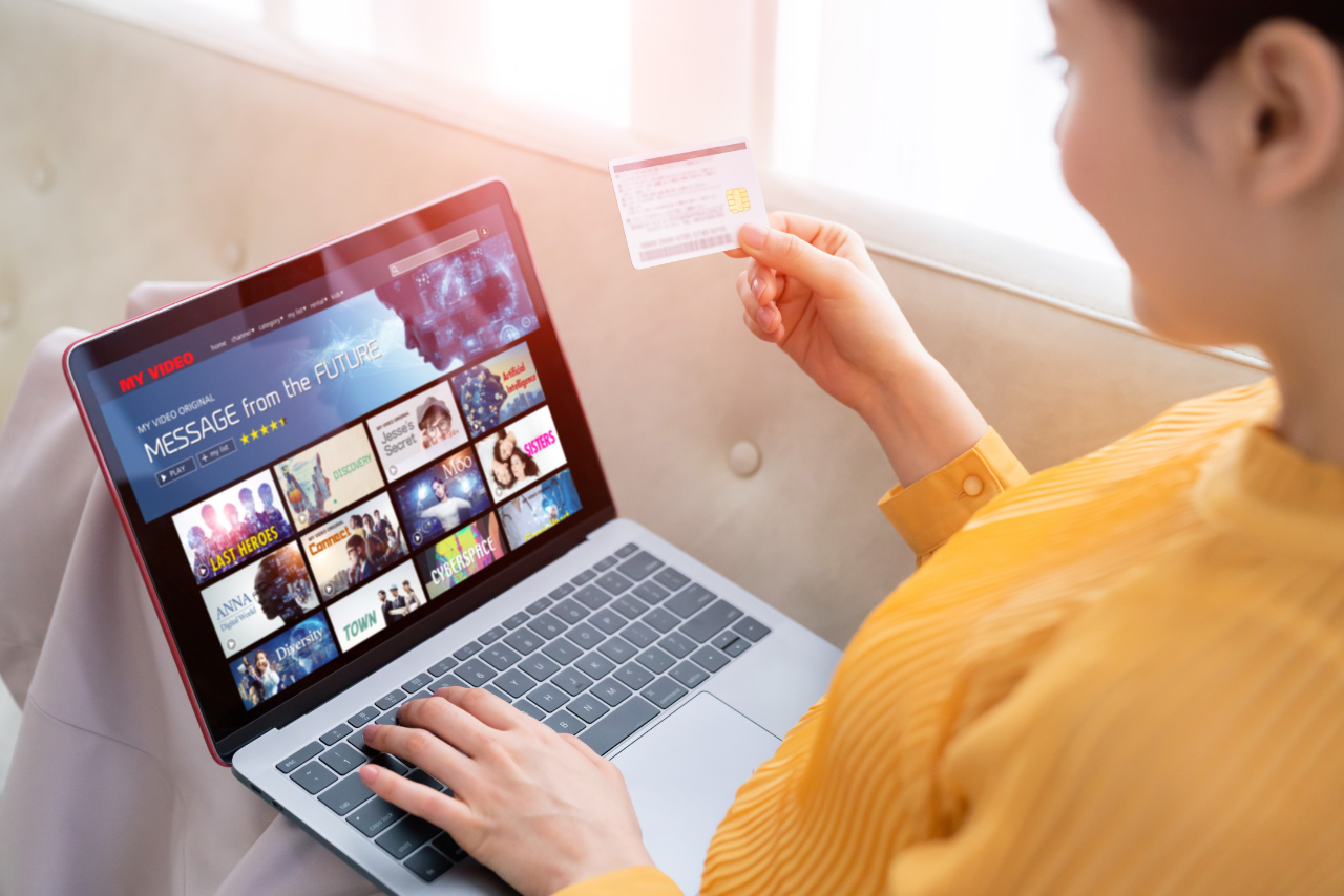 Woman paying for video subscription using credit card.