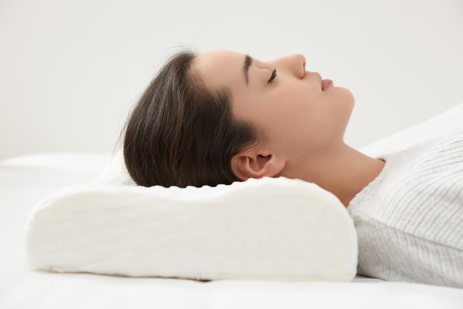 Woman sleeping on memory foam pillow indoors.