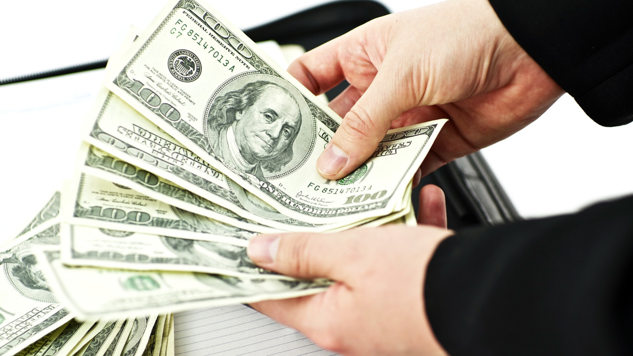 Person counting money from coaching income.