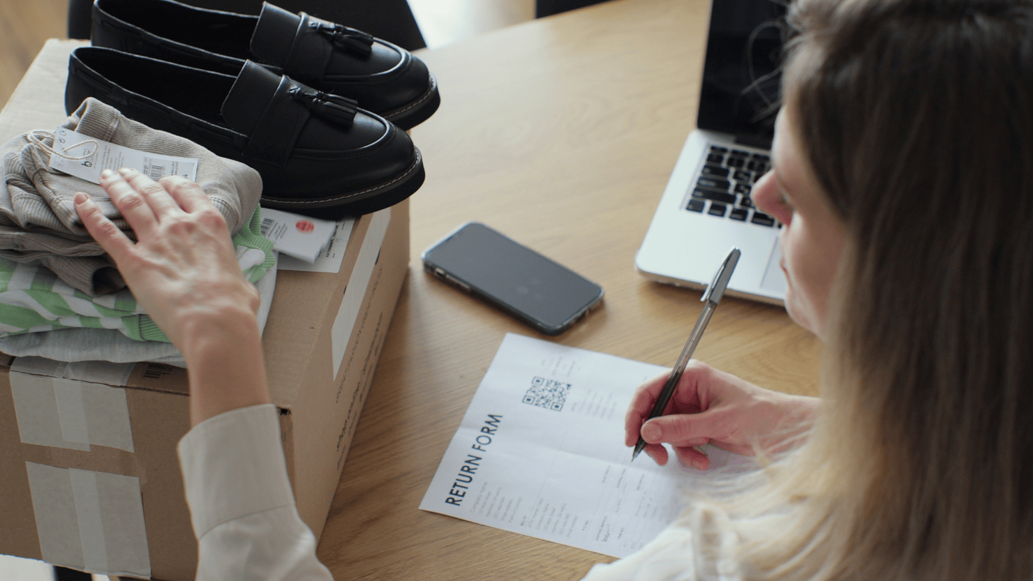 A young woman writes a return form. 