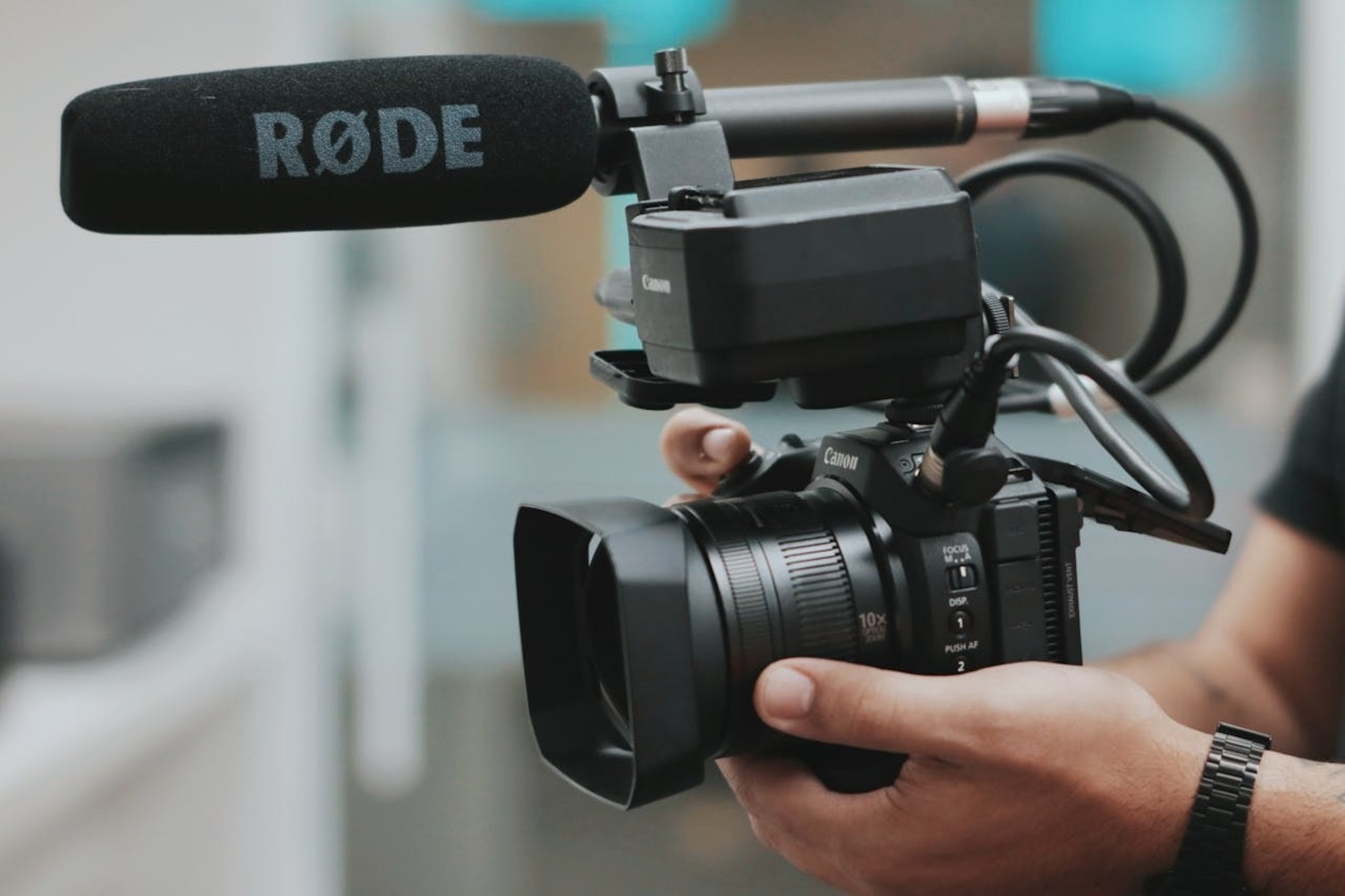 A person holding a camera with a microphone attached to it
