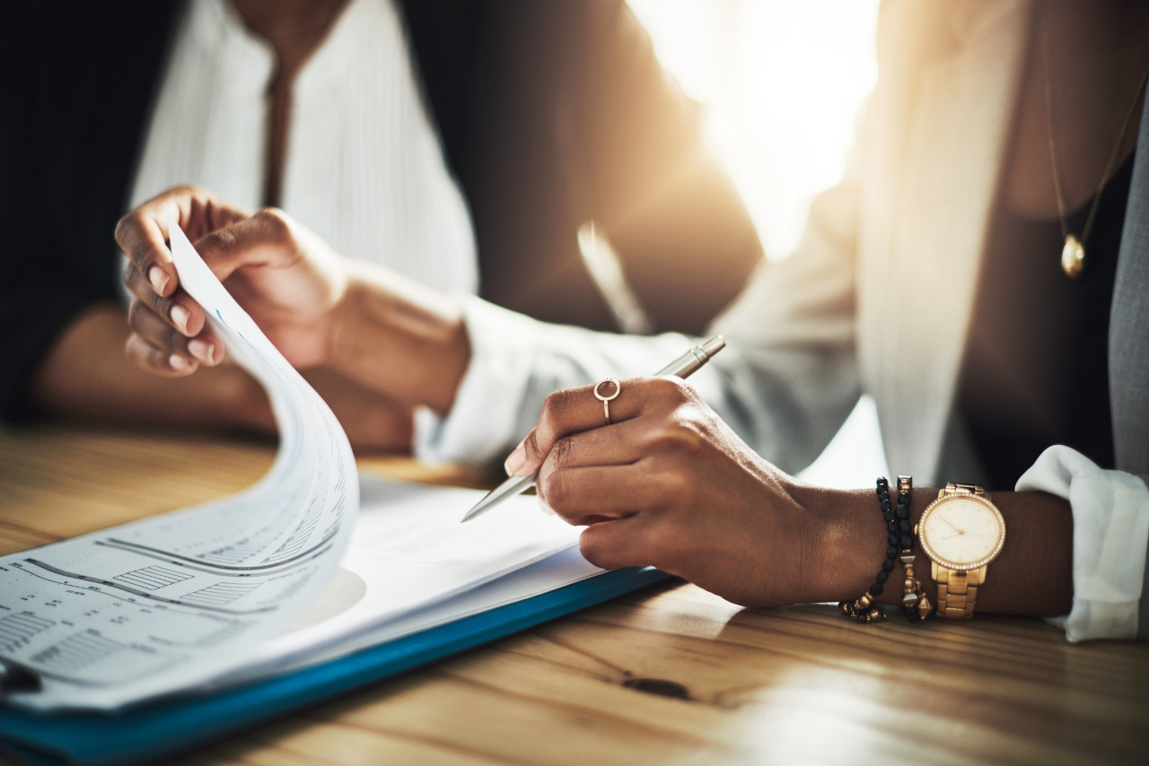 Closeup of two businesswomen going through the terms and conditions.