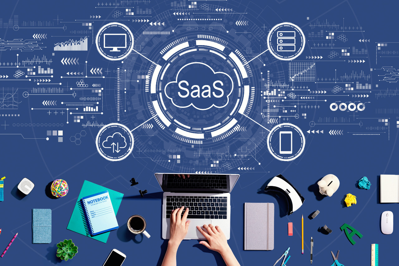 SaaS - software as a service concept with person using a laptop.