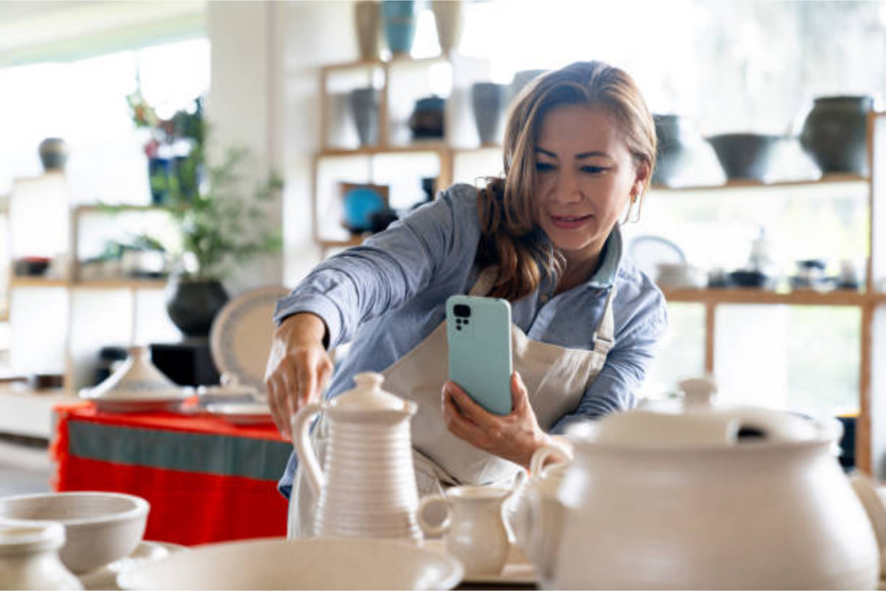 Business owner taking pictures of jar products and posting on socials.