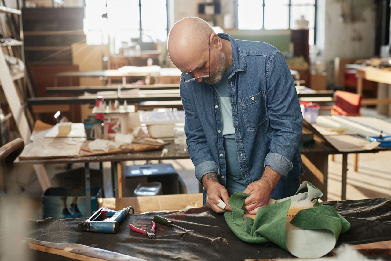 Senior Craftsman Refurbishing Furniture in Workshop.