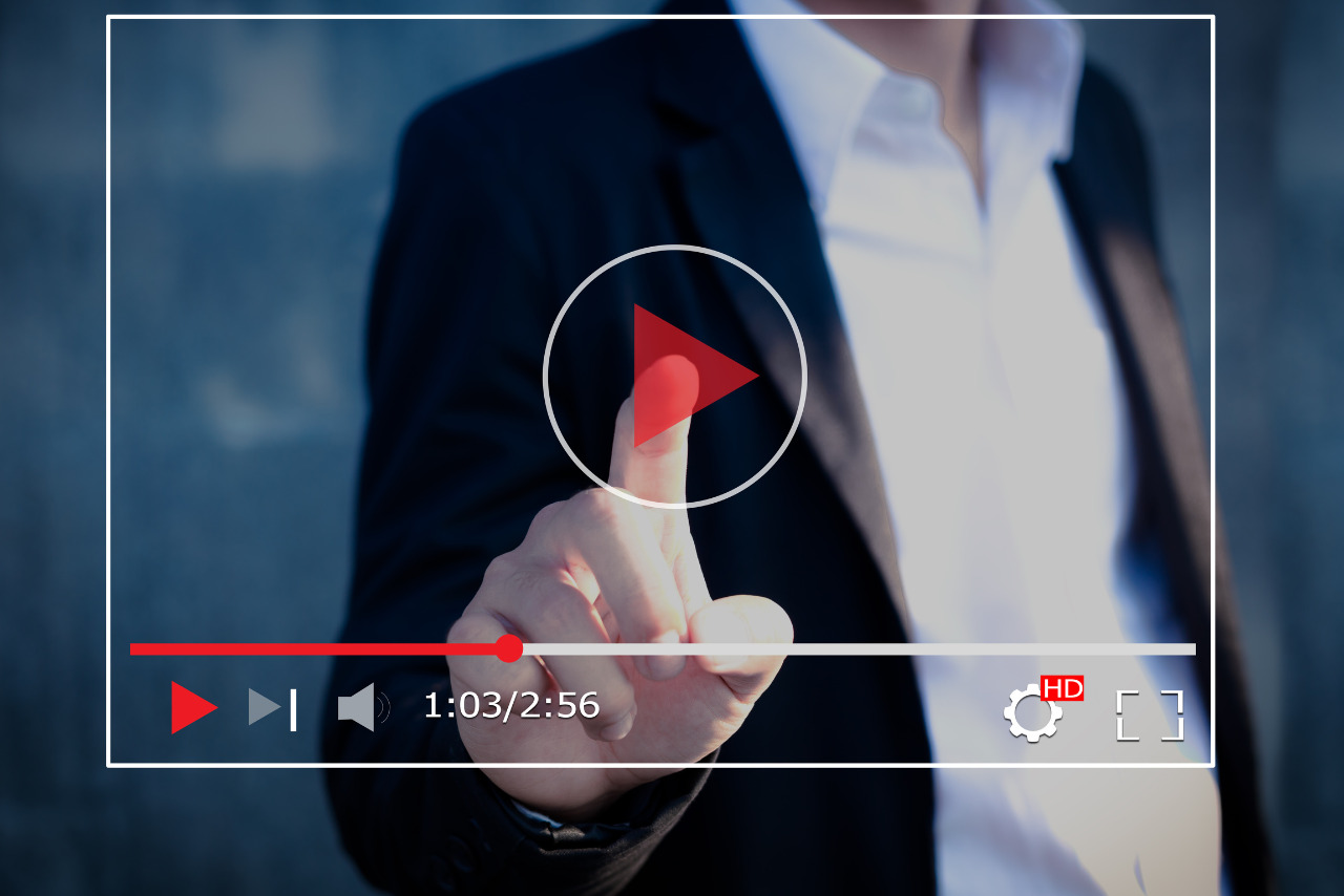 Video content with a play button being pressed.