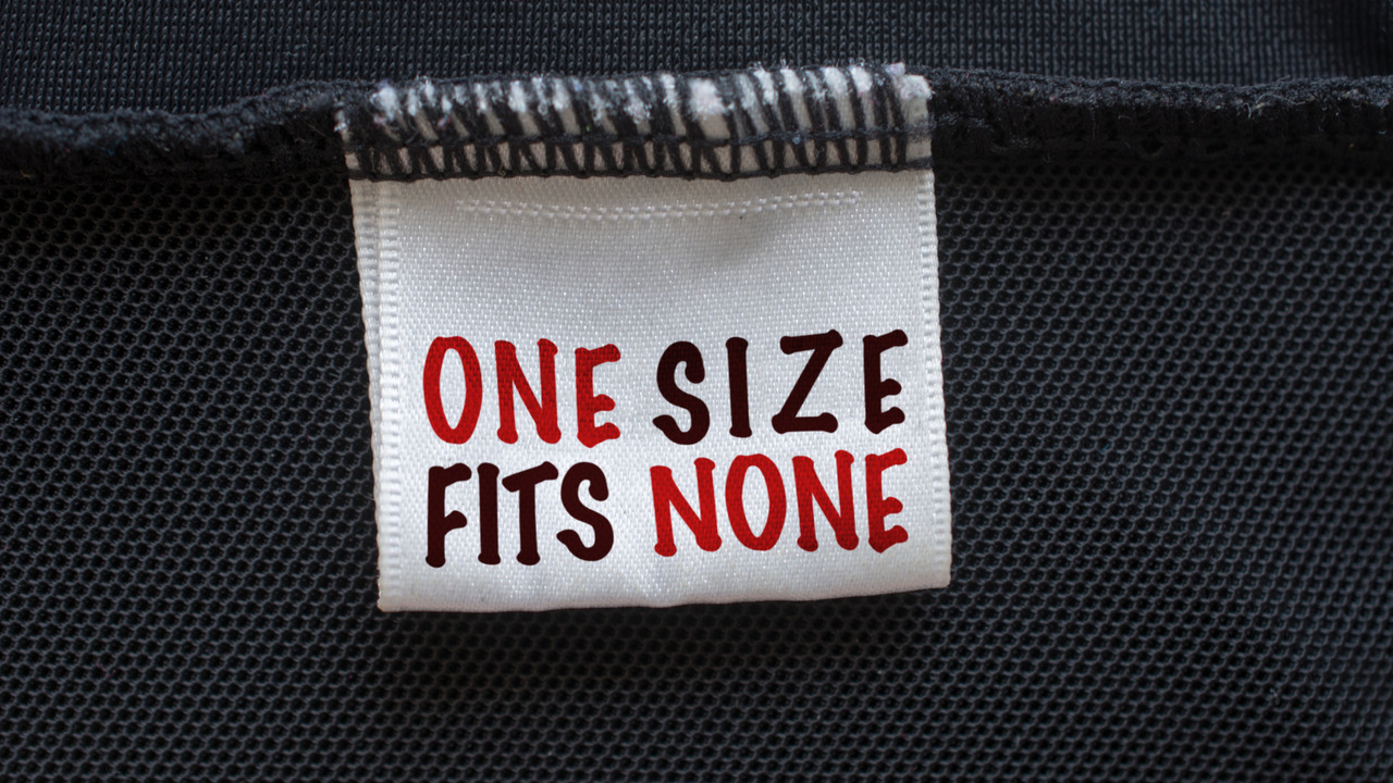 Close up of suit with label One size fits none.
