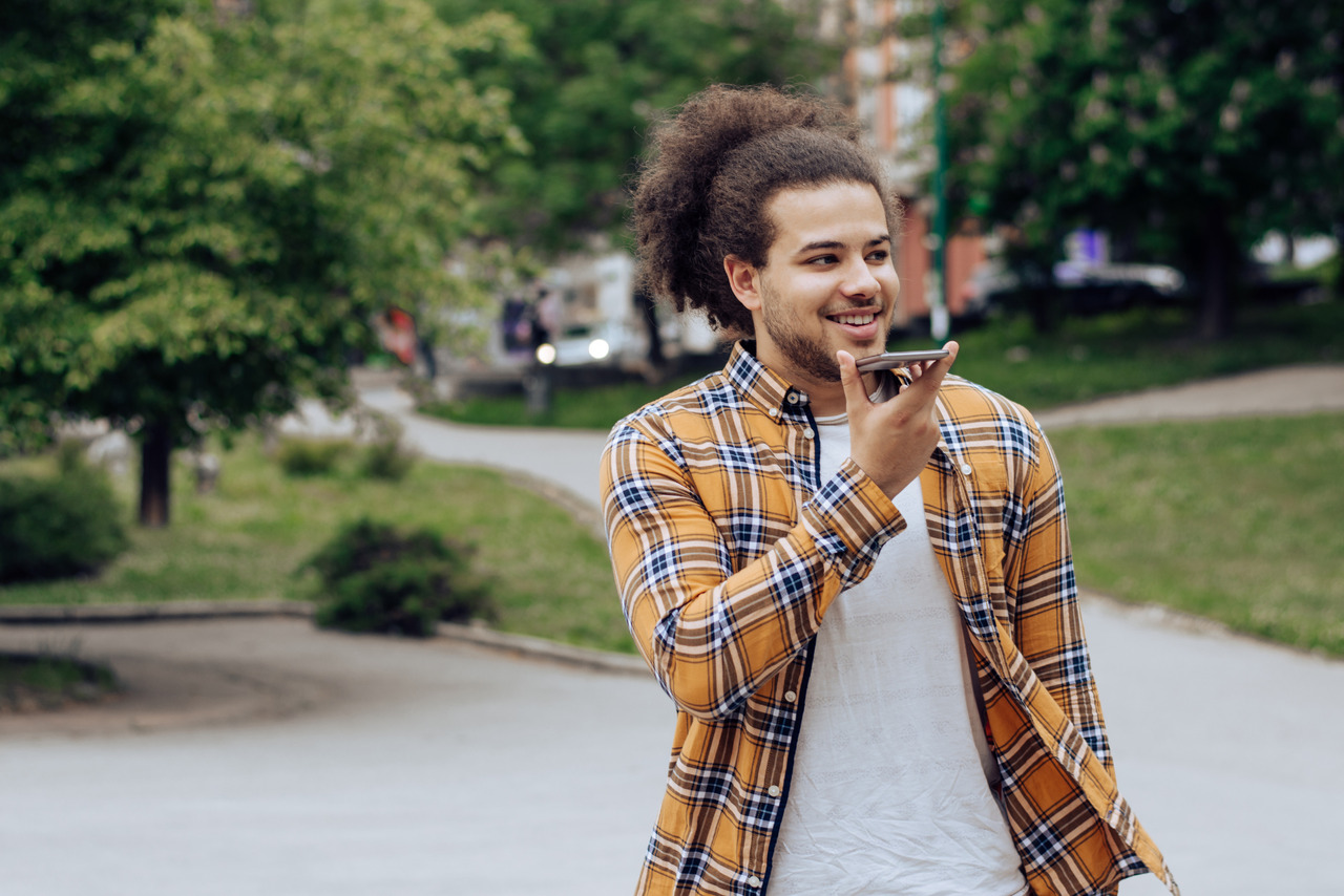Young man recording a voicemail on the move.