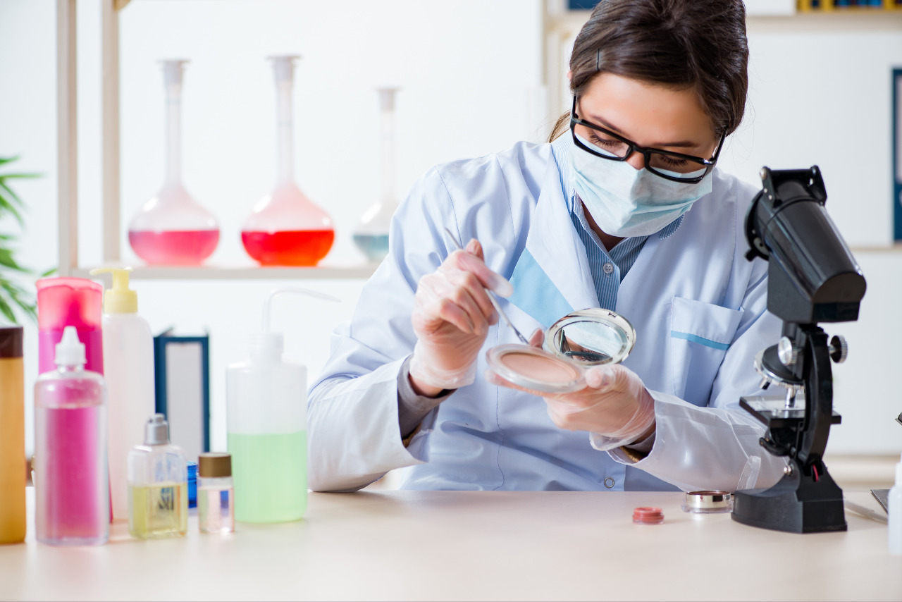 Cosmetic chemist checking quality of pressed powder.