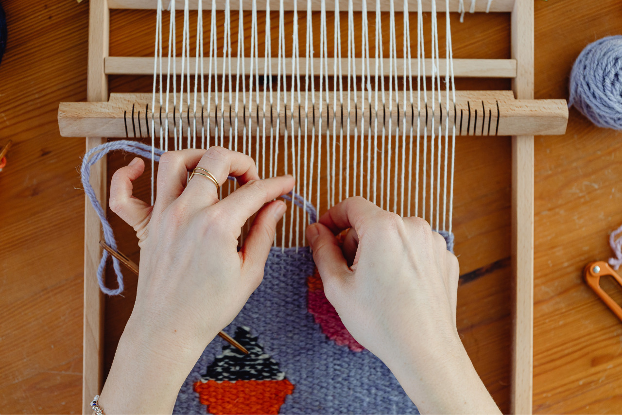 Female weaver weaving on a loom.