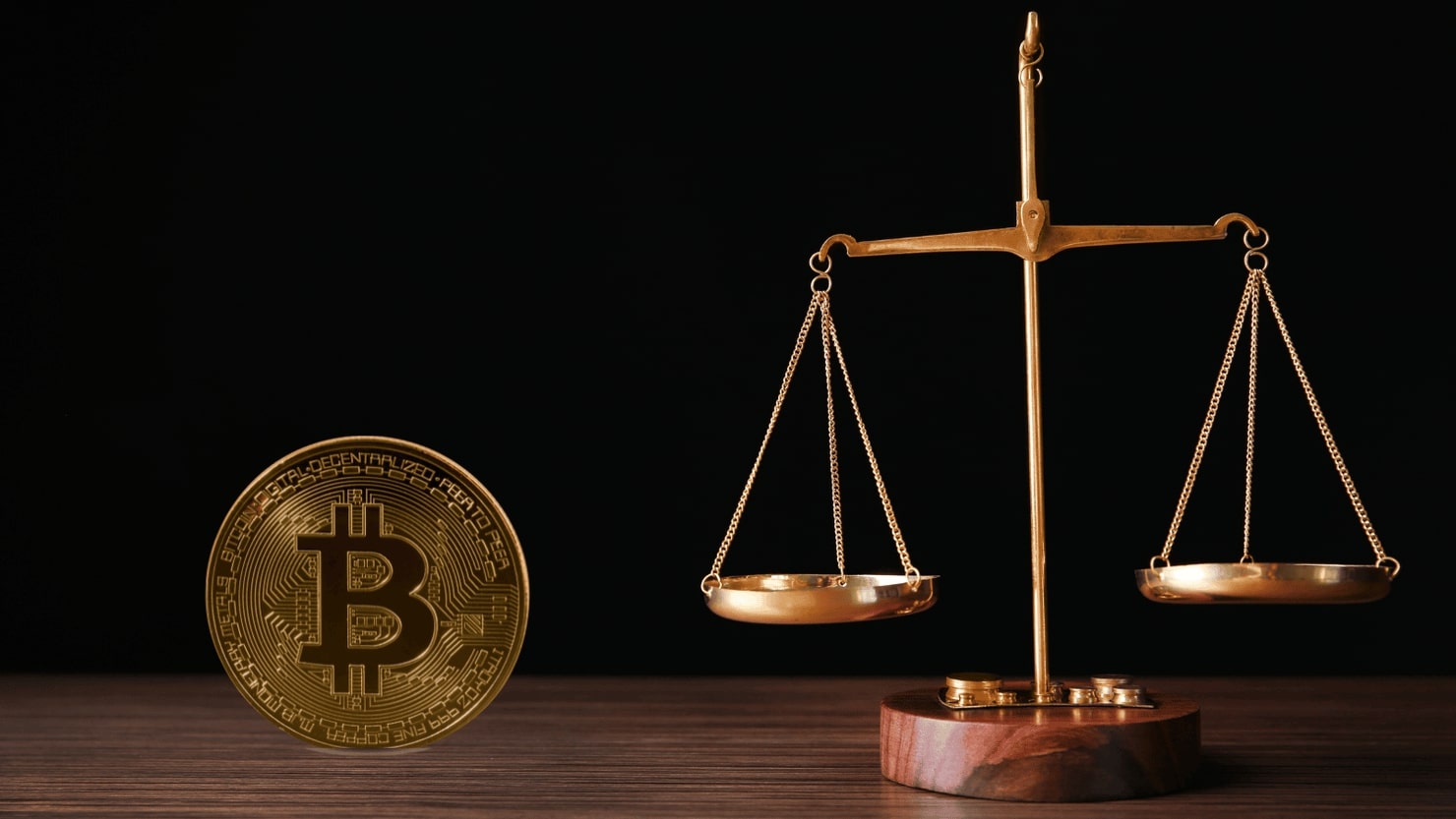 Scales of justice and a bitcoin beside it.