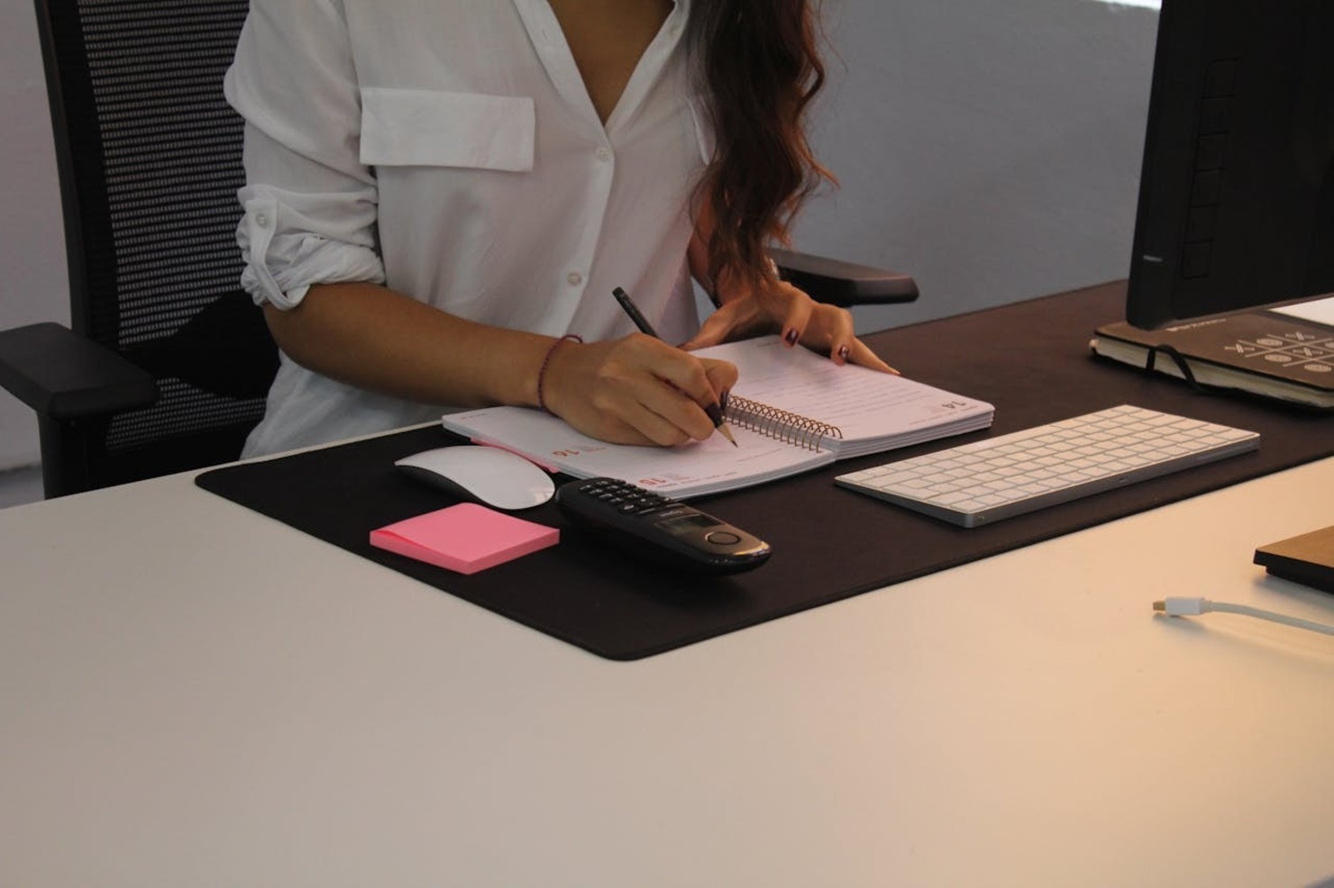 A woman sitting at a desk and writing in a notebook