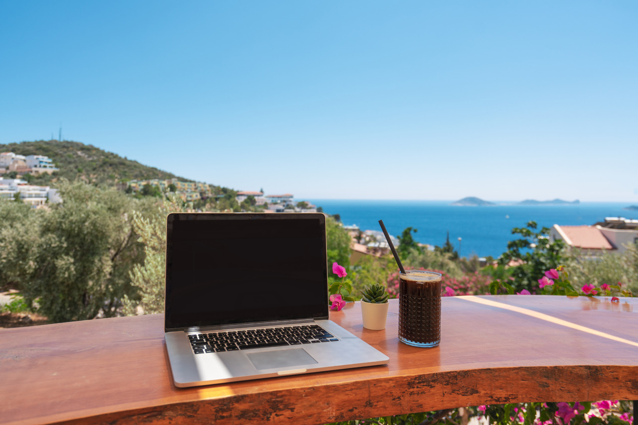 Open laptop with amazing view of ocean on the background.