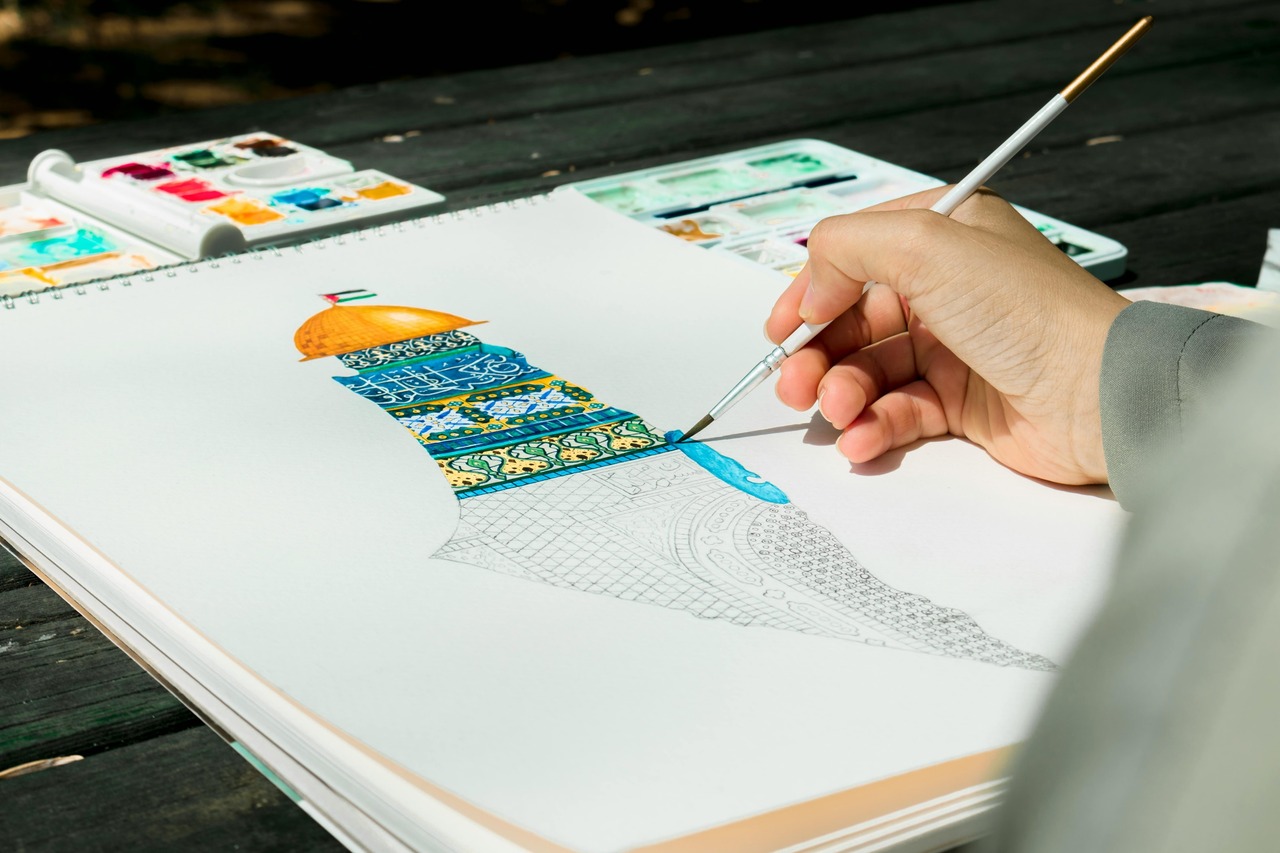 A Person Painting on a Sketchbook.