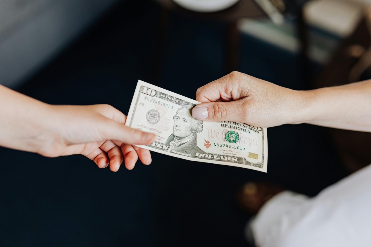 Hands Holding a 10 Dollar Bill.