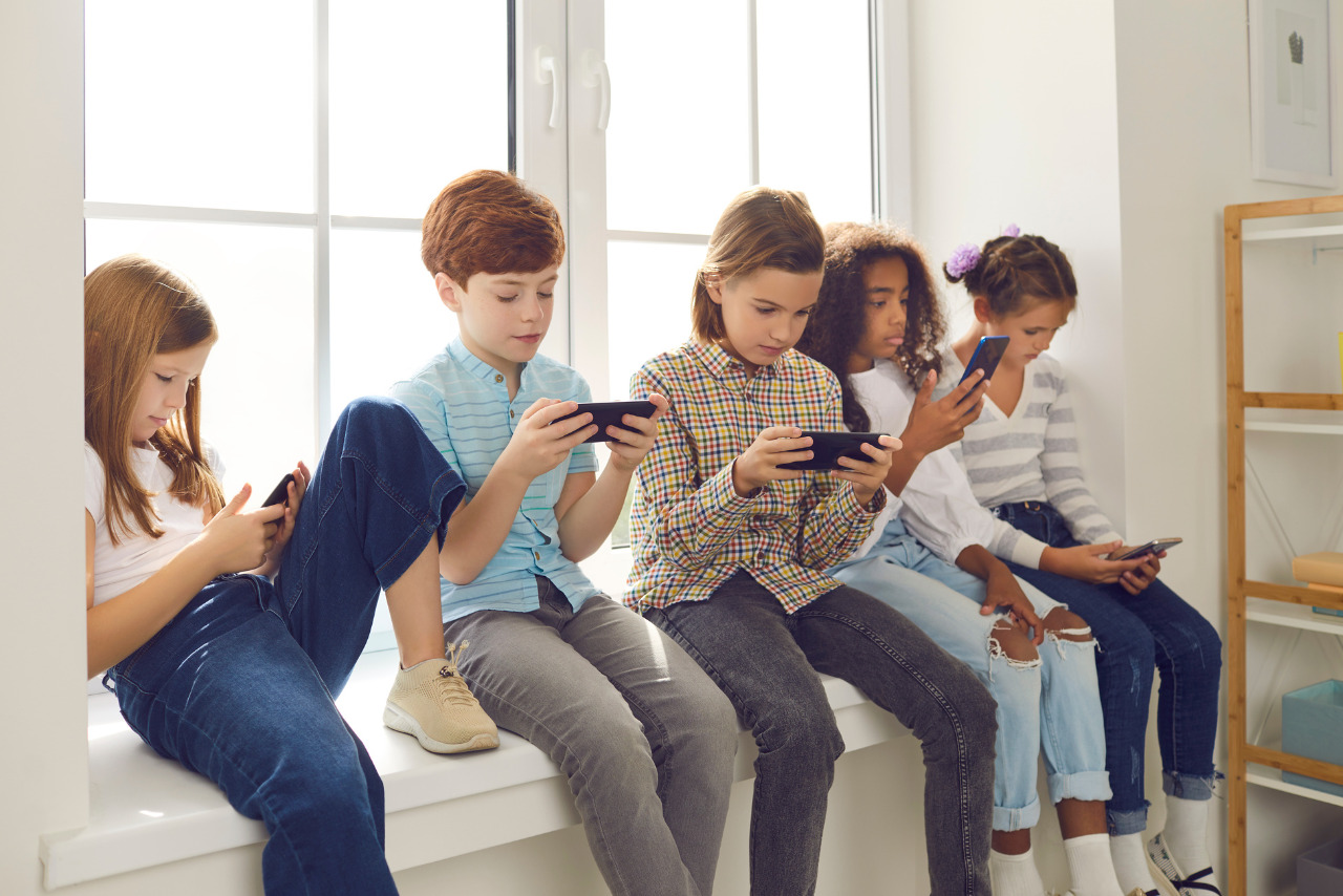 Children Sitting on Windowsill using phones.