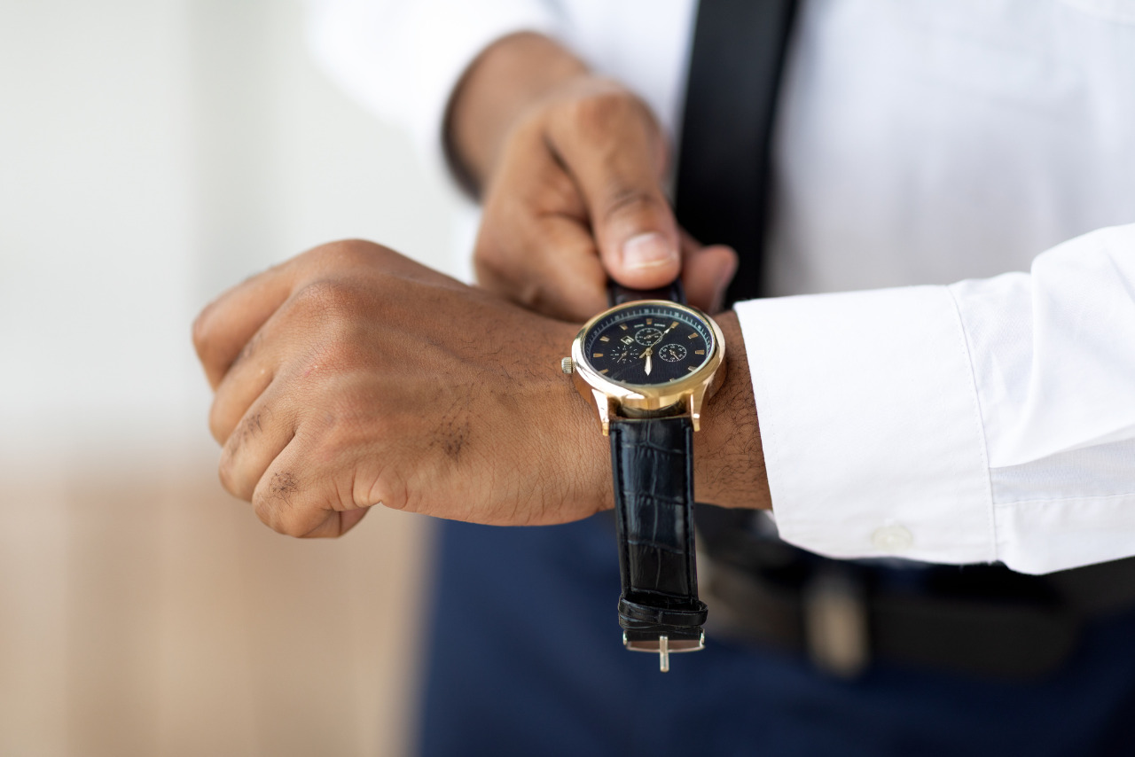 African American businessman putting expensive watch on the wrist.
