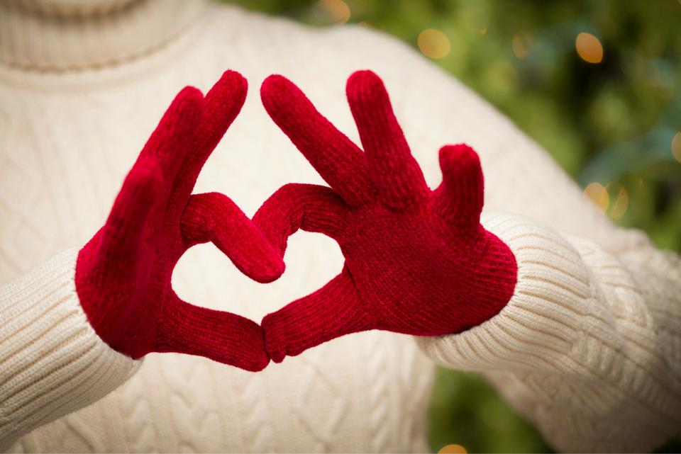 Woman wearing red mittens made from old sweater.