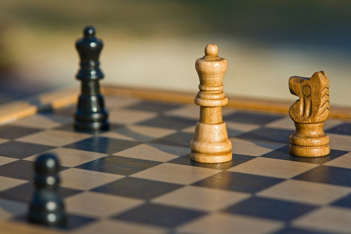 A chess board with some chess pieces in view.