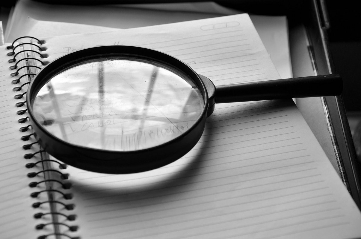 A magnifying glass on a journal.