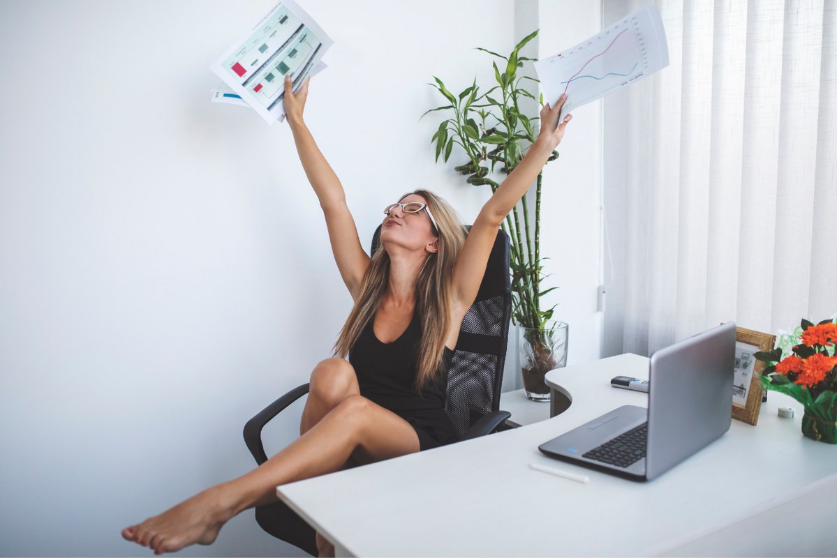 A successful female dropshipping owner cheers joyfully over her sales success.