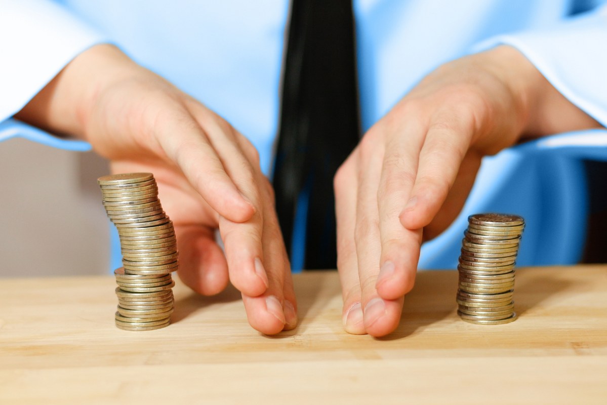 Closeup of businessman sharing profit coins.