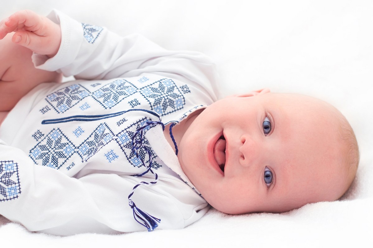 Cute infant wearing an embroidered shirt.