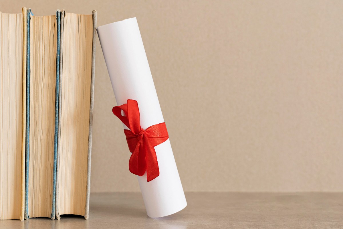 Education Diploma Certificate besides books.