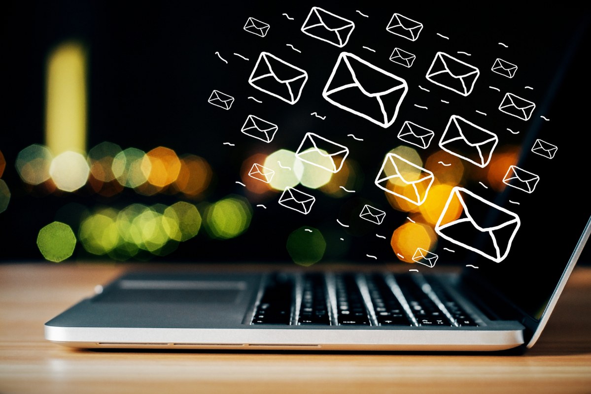 Email icons floating ontop of laptop.