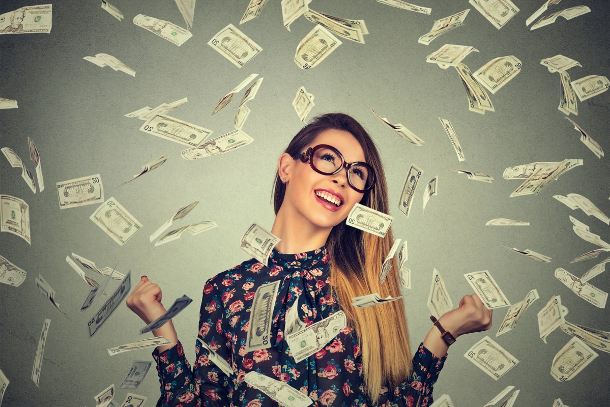 Female SEO Expert pumping fists celebrates success under money rain.