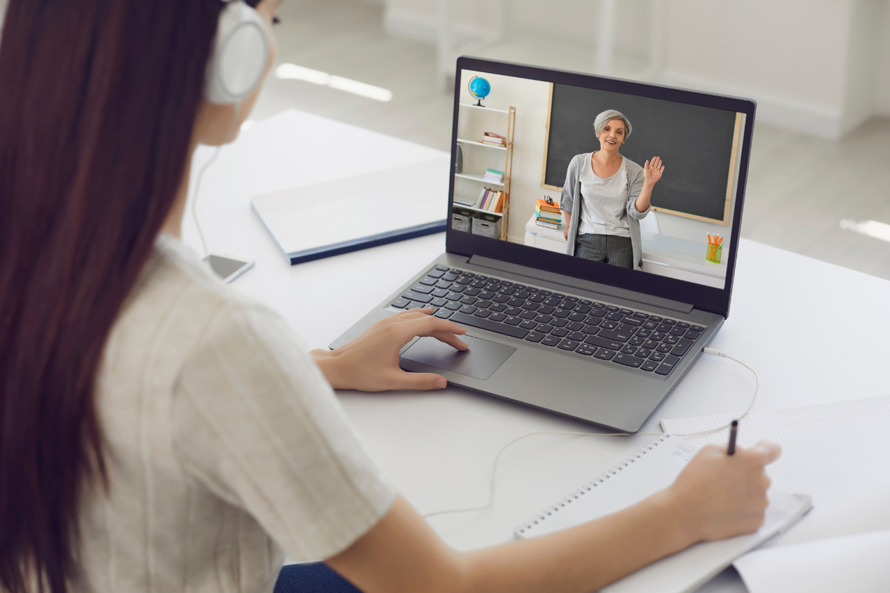 Female Student in Headphones Having Online course.
