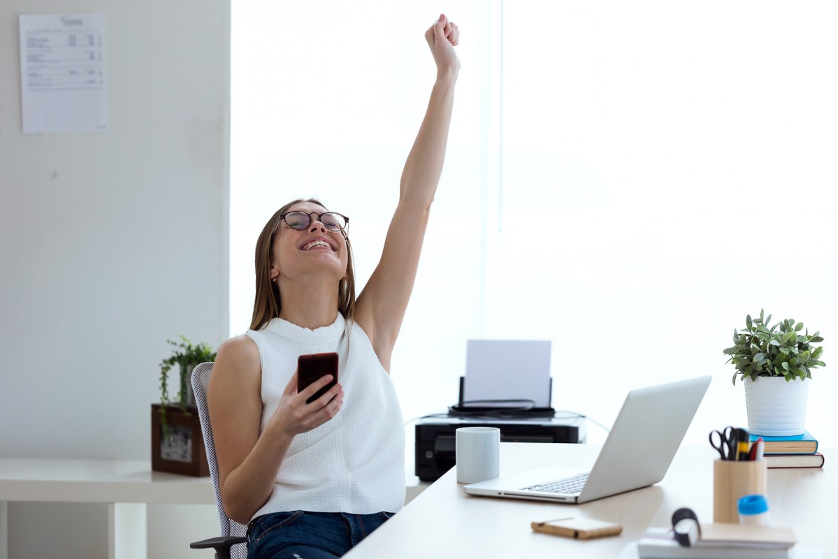 Female dropshipping entrepreneur gets excited over business success.